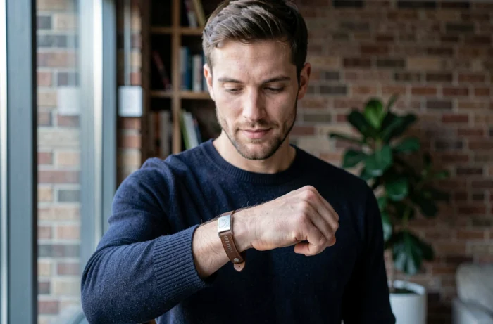 Homme portant un bracelet personnalisé en cuir et argent gravé dans un appartement moderne
