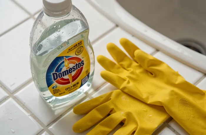 Flacon de Domestos presque vide sur un plan de travail de cuisine symbolisant la pénurie du produit